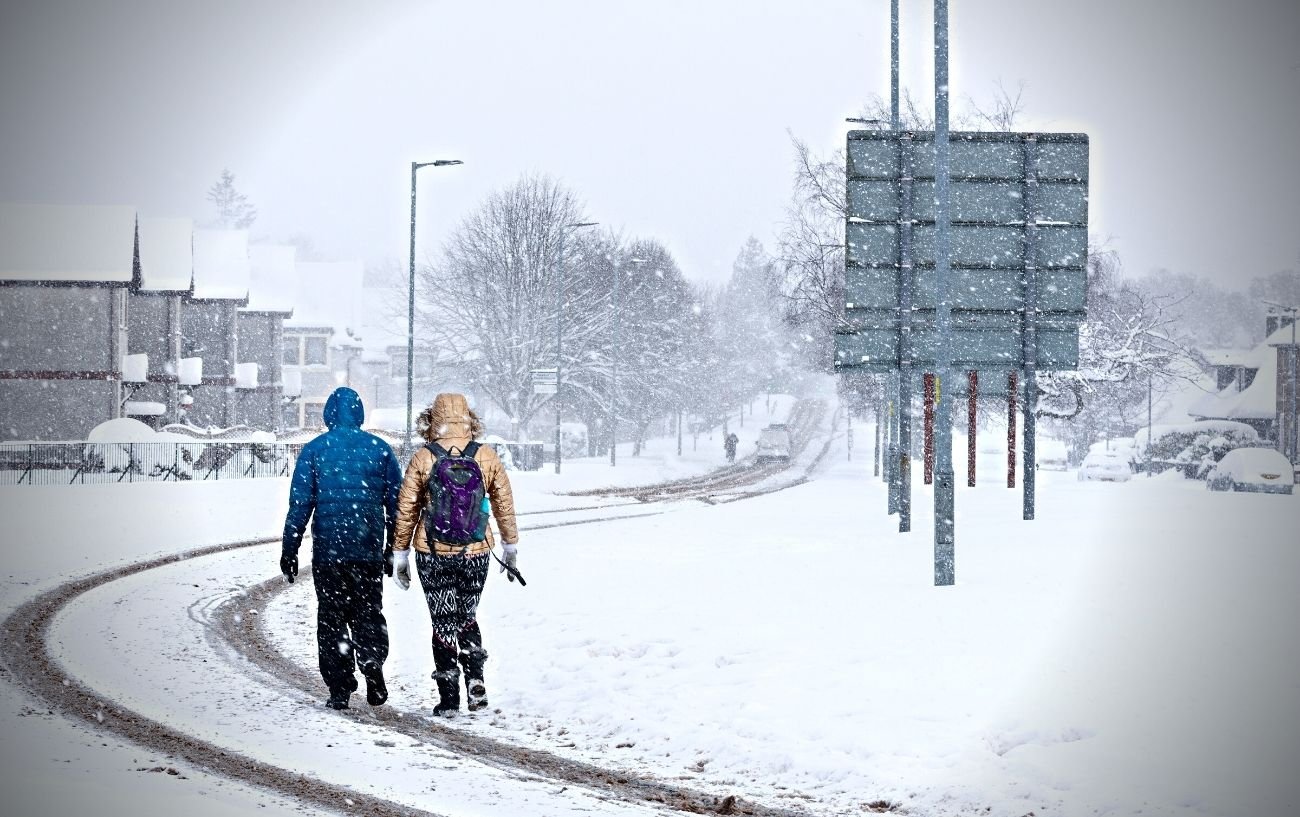 Gente caminando en una pista durante una tormenta de nieve.