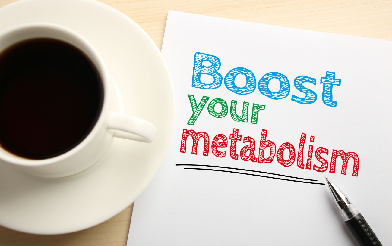 Una taza de café y un papel que dice acelera tu metabolismo.  Uno de los beneficios de un ayuno de 24 horas. 