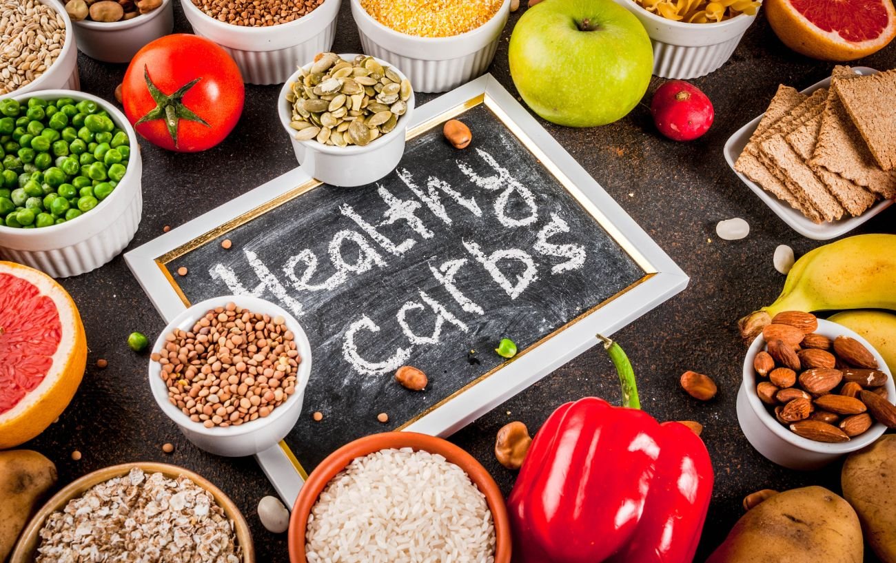 Un letrero que dice carbohidratos saludables con una variedad de carbohidratos a su alrededor.