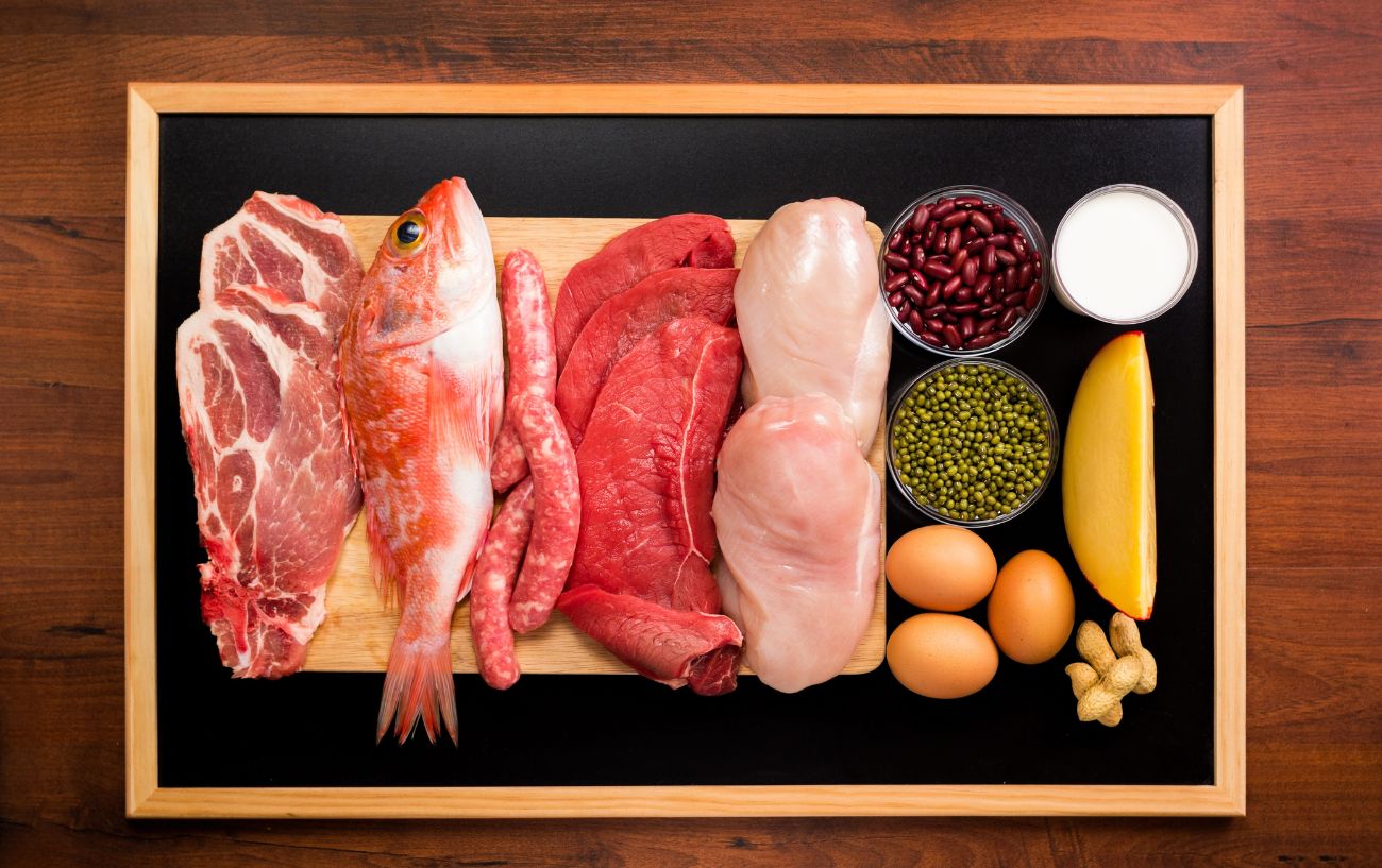 Una tabla de proteínas que incluye pescado, aves, huevos, legumbres y carne de res.