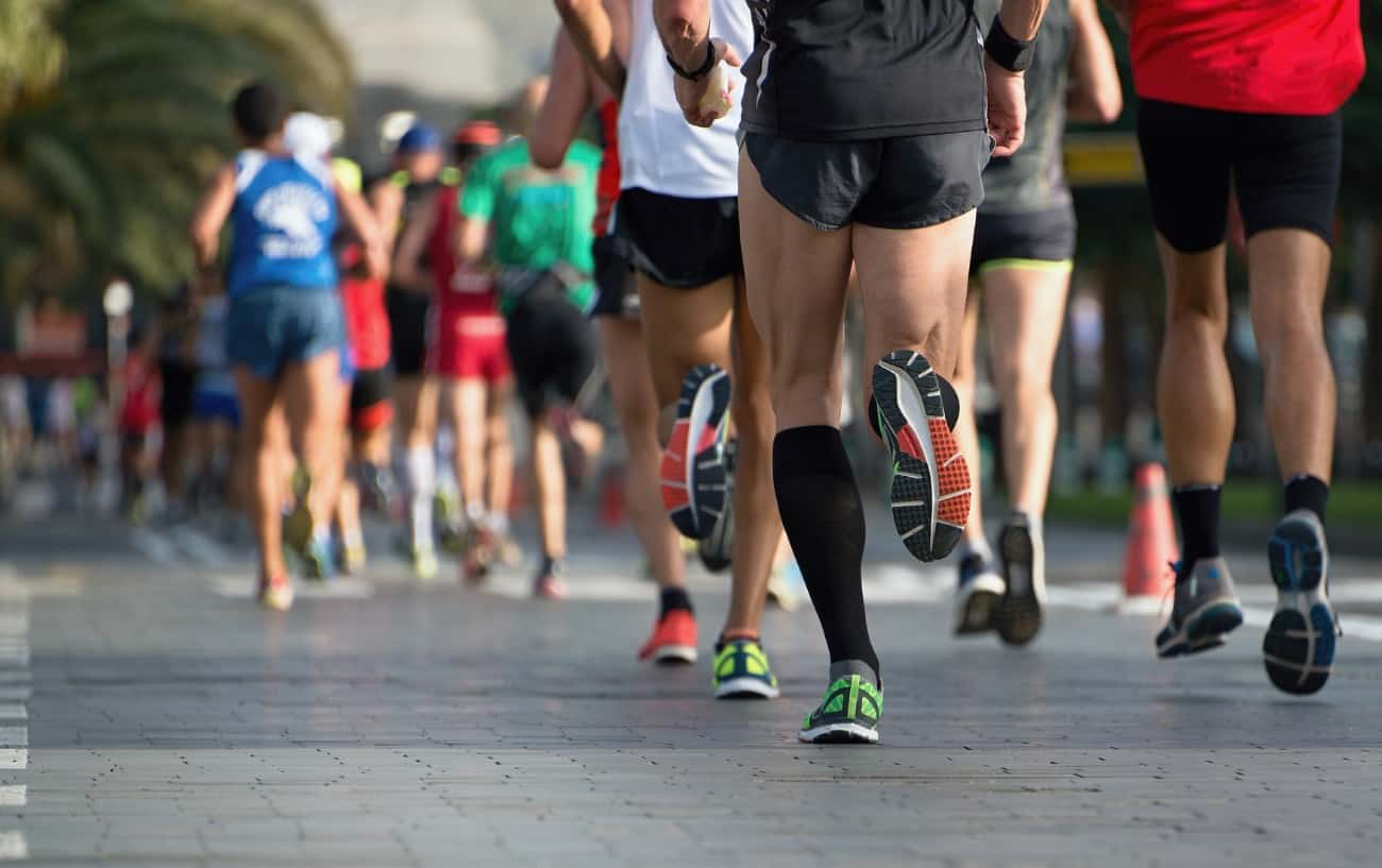 Un grupo de piernas de un corredor corriendo por un camino
