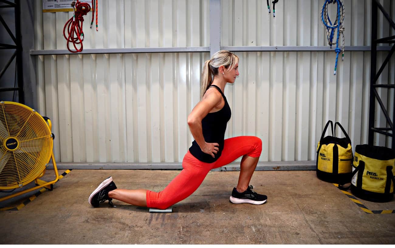Estiramientos del flexor de la cadera para corredores: una mujer que hace un estiramiento de estocadas