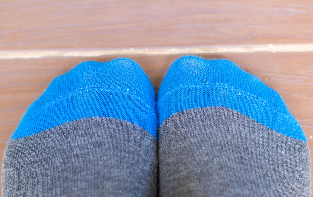 Los dedos de los pies de calcetines azules y grises.