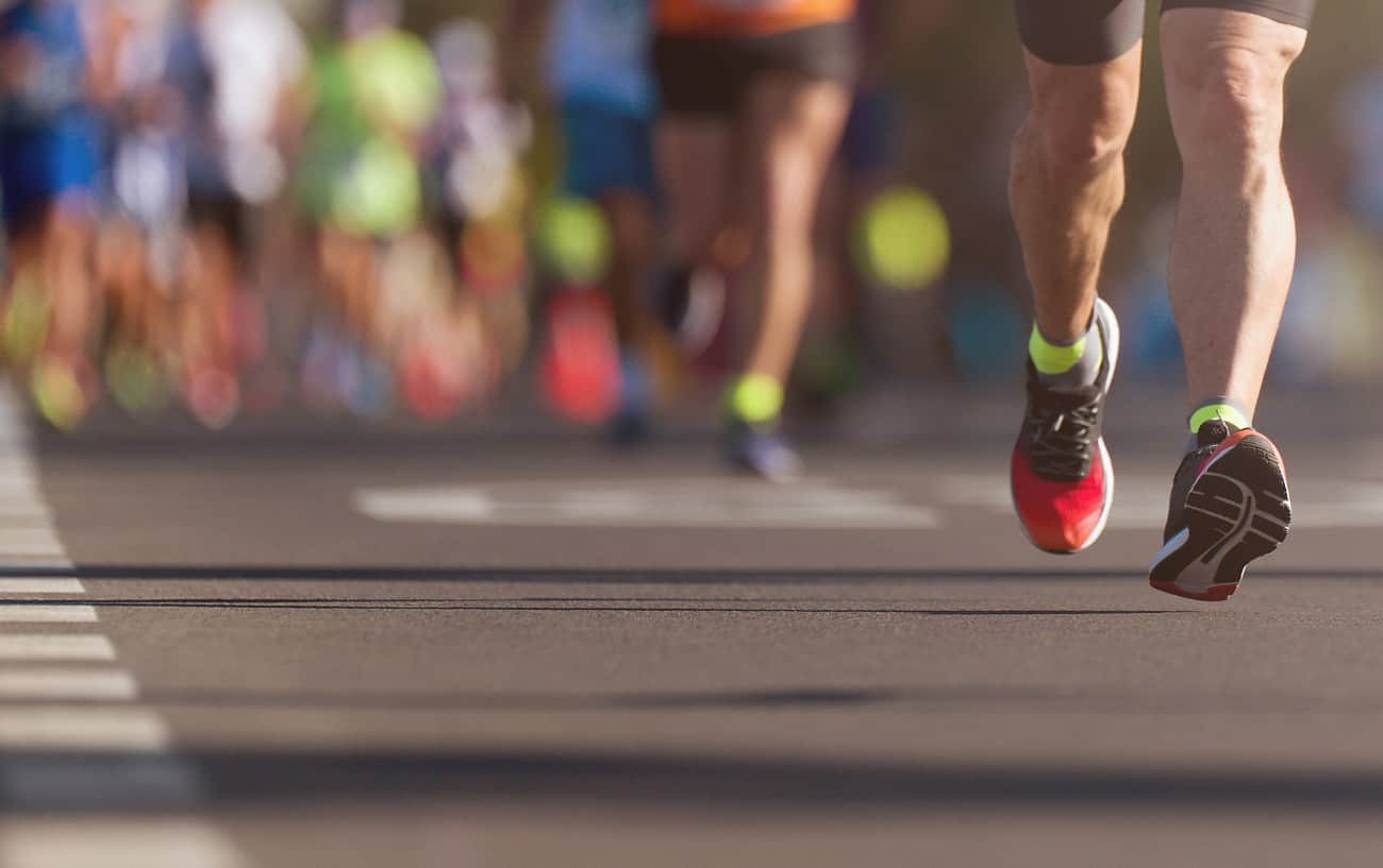 Una foto borrosa de las piernas de las personas mientras corren una maratón.