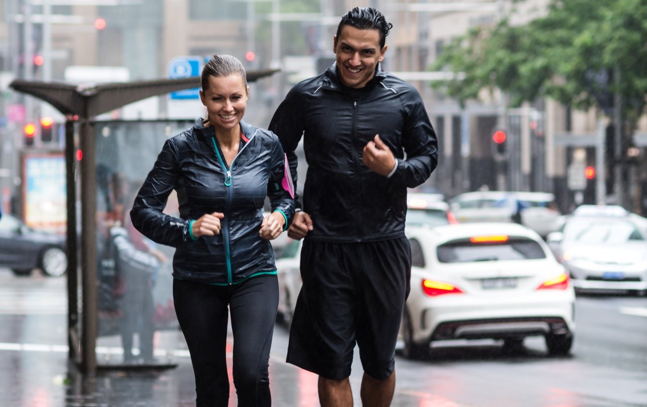 pareja corriendo bajo la lluvia