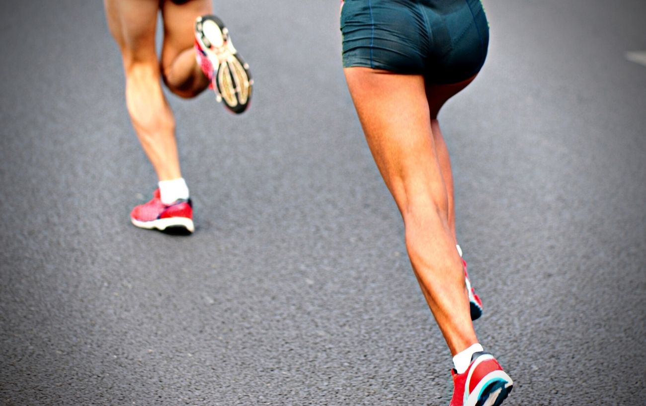 Gente corriendo rápido con piernas musculosas estiradas.