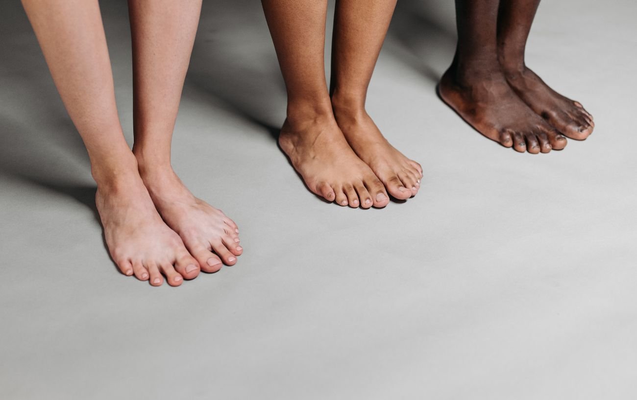 Los pies de tres personas alineados.