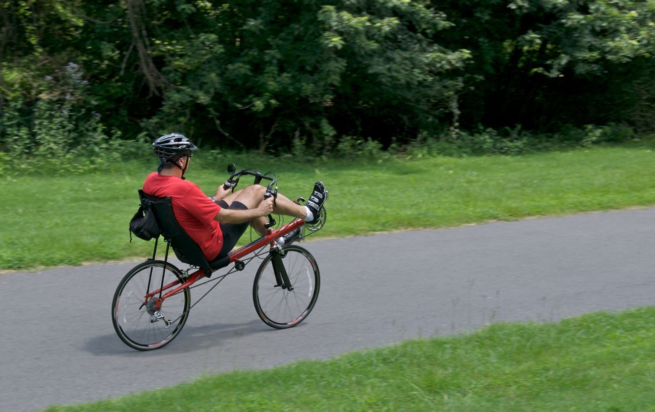 Una bicicleta reclinada al aire libre y un ciclista.