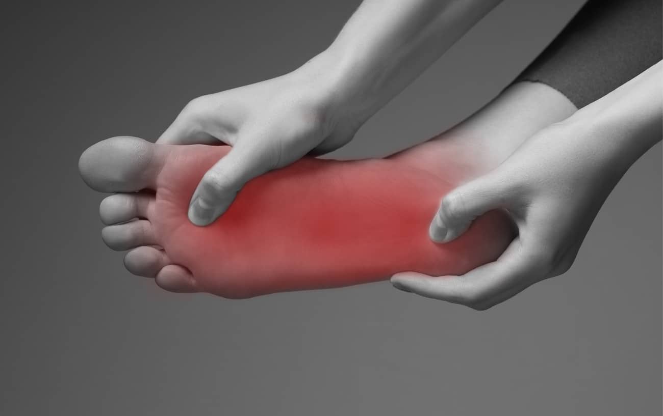Un primer plano del pie de una persona con un brillo rojo que indica dolor.